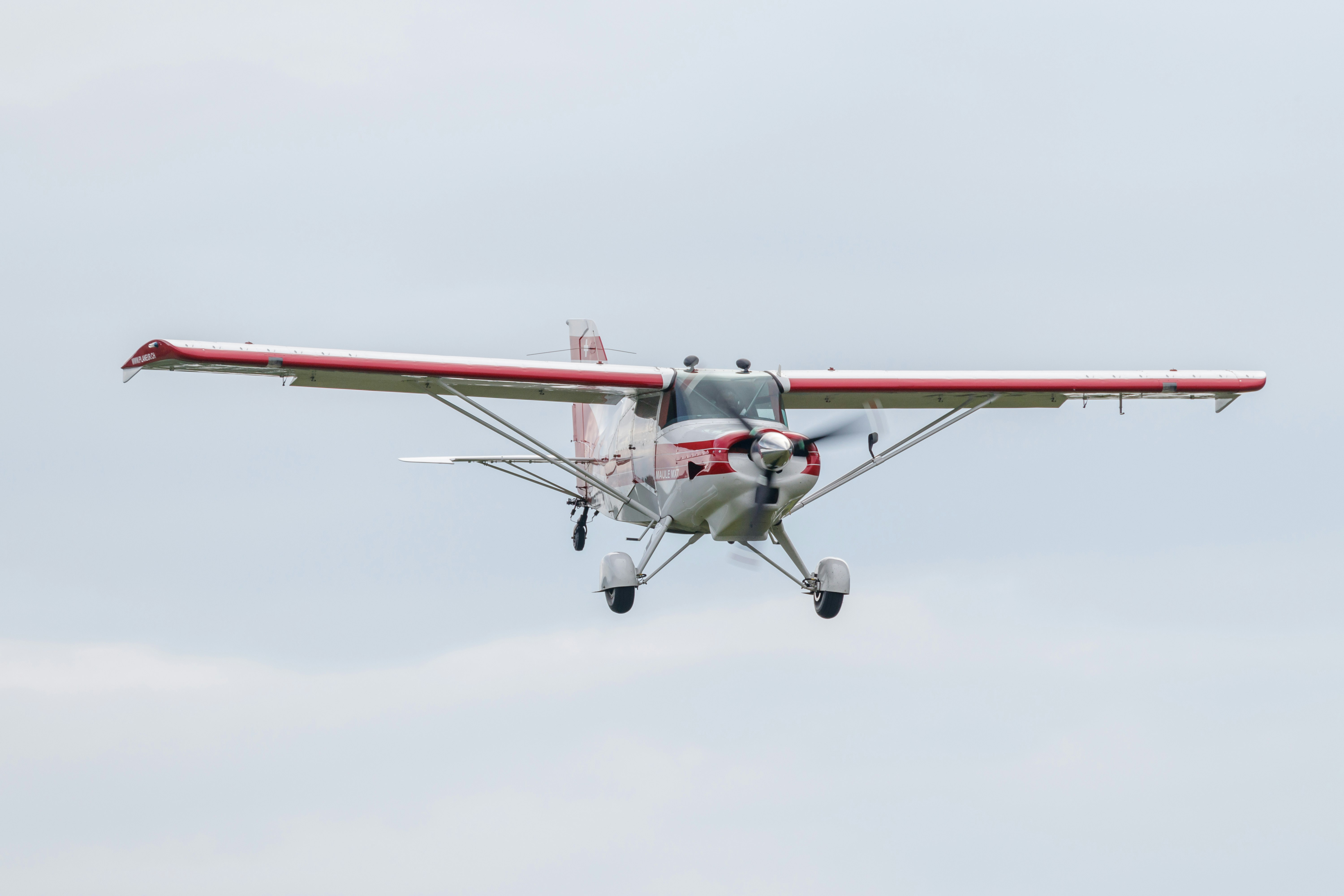 flying red and white biplane during daytime